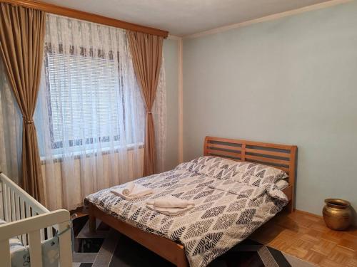 a bedroom with a bed and a window at Apartman Dačo in Vlasenica
