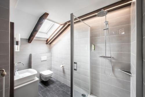 a bathroom with a shower and a toilet and a sink at Sporthotel Bernrieder Hof GmbH in Bernried
