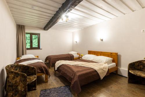 a room with two beds and two chairs in it at Hämsa Maheresto & Heaolukeskus in Võru