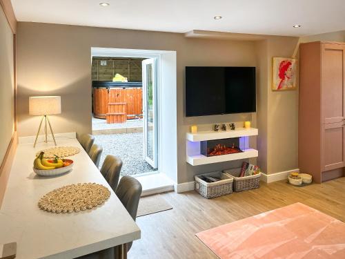 a living room with a table and chairs and a television at Pasture Barn in Barnard Castle