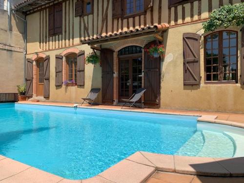 a large blue swimming pool in front of a building at Guest House, Private Pool in LʼIsle-en-Dodon