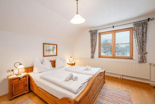 a bedroom with a large bed and a window at Stanglhof - by myNests in Bad Aussee