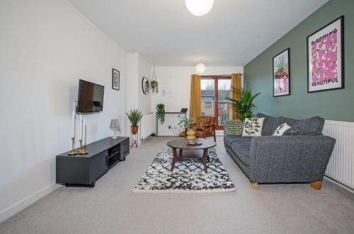a living room with a couch and a tv at 2Bed City Central East End Gem with Free Parking in Glasgow