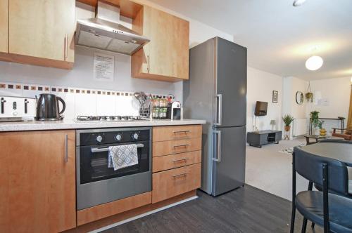 a kitchen with a stove and a refrigerator at 2Bed City Central East End Gem with Free Parking in Glasgow