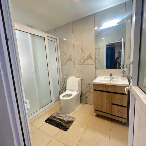 a bathroom with a toilet and a sink and a mirror at A Cube Homestay in Bharatpur