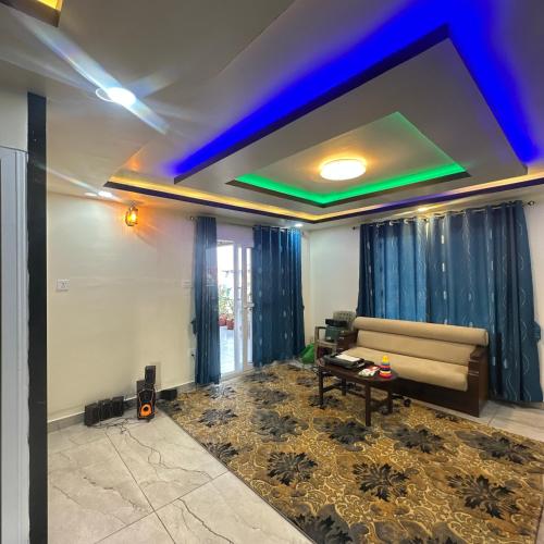 a living room with a couch and a blue ceiling at A Cube Homestay in Bharatpur