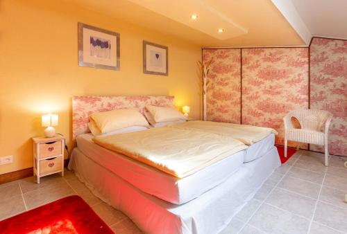 a bedroom with a large bed and a chair at Private gîte with stunning views & shared pool in Laussou
