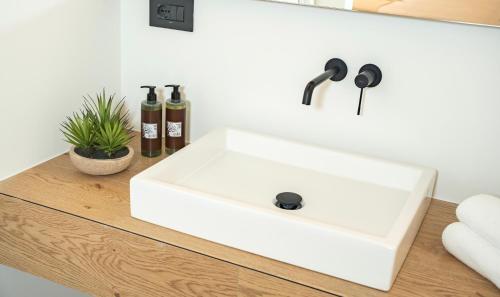 a white bathroom sink on a wooden counter at ARIA Collection Bari in Bari
