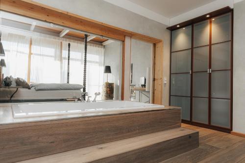 a large bath tub in a room with a bed at Luxus Seaside Loft in Füssen
