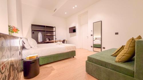 a bedroom with a bed and a green couch at ARIA Collection Bari in Bari
