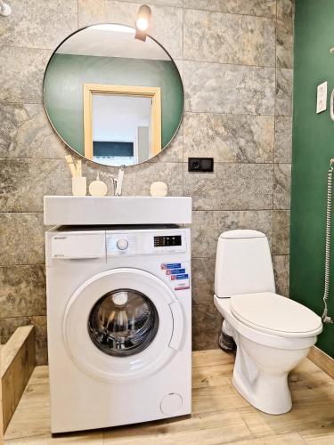 a bathroom with a washing machine and a toilet at Dunes Trail 2 in Melnragė