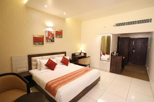 a hotel room with a large bed with red pillows at The White Pearl Suites in Bangalore