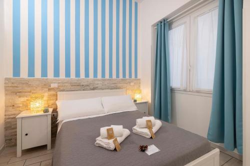 a bedroom with a bed with towels on it at Approdo Rooms - Eja Sardinia in Cagliari