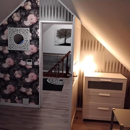 a room with a staircase with a wall covered in flowers at Darpvenner Diele in Ostercappeln
