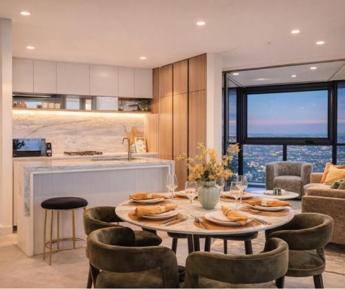 a kitchen and dining room with a table and chairs at 2Bed Luxe Queens Wharf Apt - Carpark and city view in Brisbane