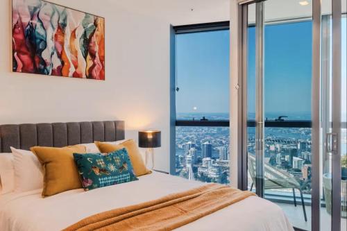 a bedroom with a bed with a large window at 2Bed Luxe Queens Wharf Apt - Carpark and city view in Brisbane