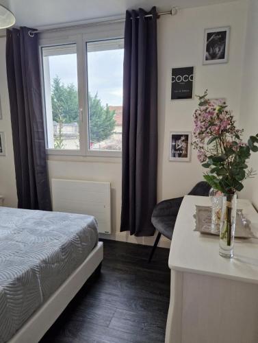a bedroom with a bed and a table and a window at Le Peekskill in Montbron