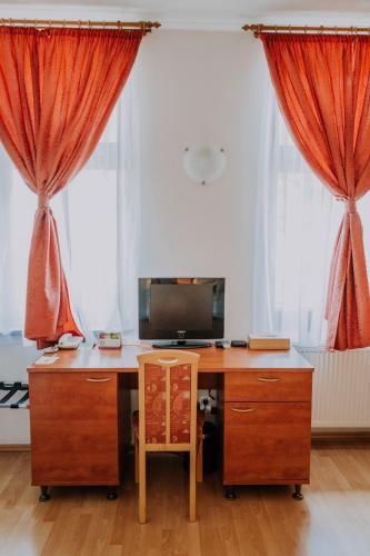 an office with a desk and red curtains at The Rooms by Dalia in Košice