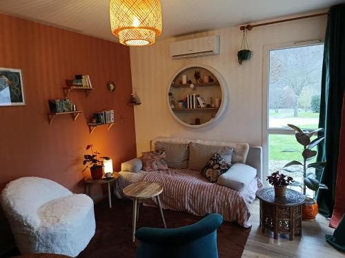 a living room with a couch and a mirror at Maisonnette dans son écrin de verdure in Saint-Geniez-dʼOlt
