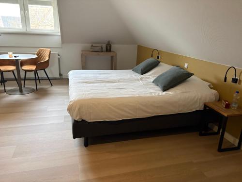 a bedroom with a bed and a table and chairs at B&B Witvliet, kamers en studio met heerlijk ontbijt ! in Zoutelande