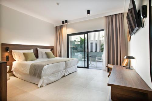 a bedroom with a bed and a sliding glass door at Hotel Coral Cotillo Reef in El Cotillo