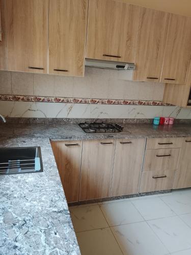 a kitchen with wooden cabinets and a counter top at Razzak in Rabat