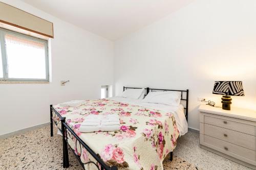 a bedroom with a bed and a dresser and a window at Villetta Degli Aranci in San Foca