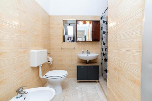 a bathroom with a toilet and a sink and a mirror at Villetta Degli Aranci in San Foca
