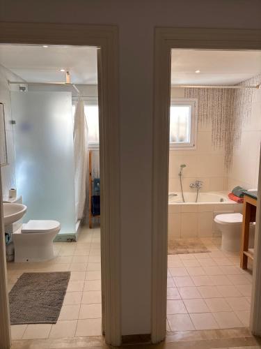 a bathroom with two toilets and a tub and a sink at Maison casa bloom - La marsa in Bin Rhilouf