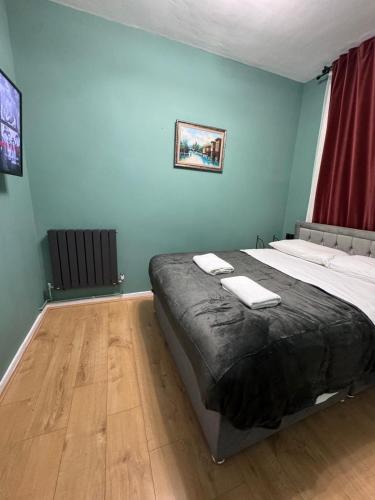 a bedroom with a large bed with towels on it at Euston Central Apartment in London