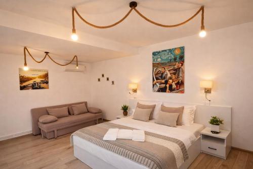 a bedroom with a large bed and a couch at Casa Elis Piscina, Jacuzzy , Sauna, Ciubar in Merei