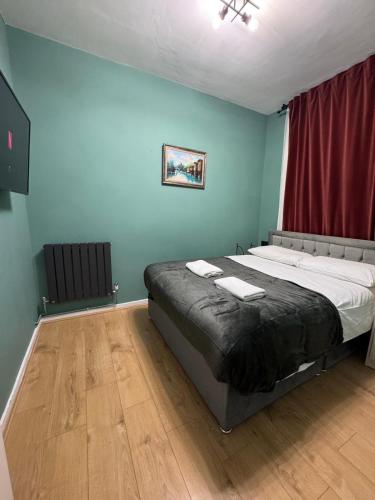 a bedroom with a large bed with a red curtain at Euston Central Apartment in London