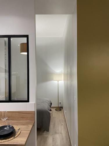 a room with a mirror and a bed and a lamp at Cozy Studio with Terrace in Cers