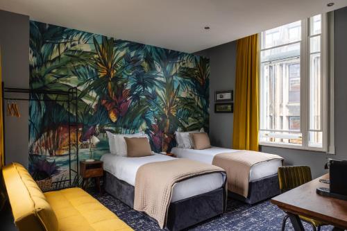 two beds in a room with a painting on the wall at The Market House in Reading