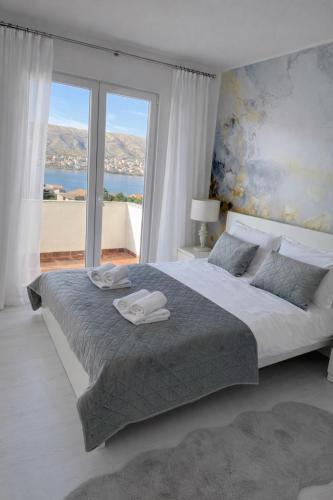 a bedroom with a large bed with a large window at Villa Una Maris - renovated 2026 in Pag