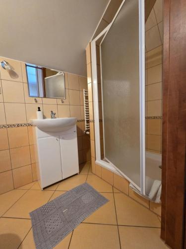a bathroom with a sink and a shower at Apartamenty Cafe Wielbark in Wielbark