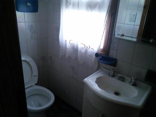 a bathroom with a toilet and a sink and a window at Chalet con pileta in Miramar