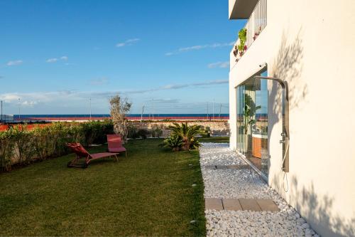 a patio with a red bench next to a building at Villa fronte mare in Bari