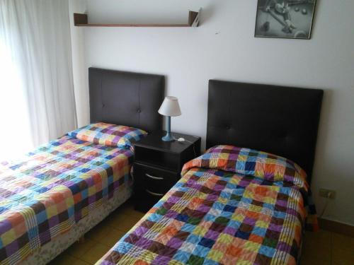 two beds sitting next to each other in a bedroom at Chalet con pileta in Miramar