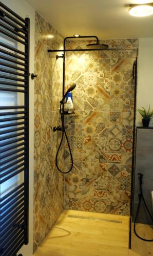 a bathroom with a shower with a stone wall at Casa Vista Duna - Kijkduin in The Hague
