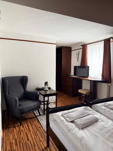 a bedroom with a bed and a chair and a television at Motel M in Malacky