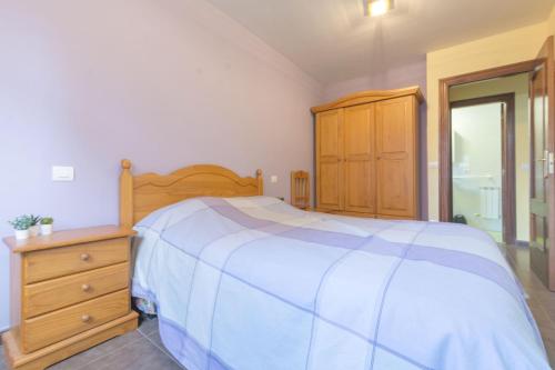 a bedroom with a bed and a dresser and a bathroom at Gibaja Apartmento con Jardin in Gibaja