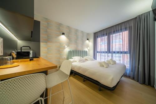 a bedroom with a bed and a desk and a window at Alicante Smart Accommodation in Alicante