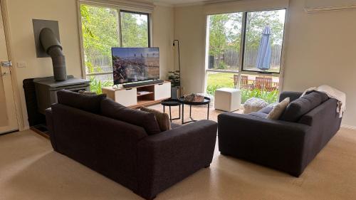 a living room with two couches and a flat screen tv at Las Elenas in Magpie