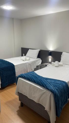 a room with two beds and a table with at Seu Hotel in Patos