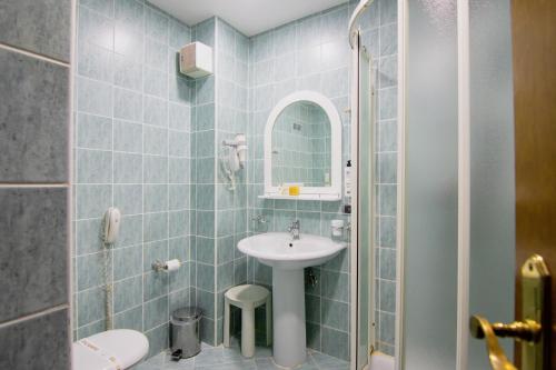 a bathroom with a sink and a mirror at Grand Hotel & Spa Tirana in Tirana