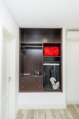 a kitchen with black cabinets and a red blanket at Art'Otel Barcelos in Barcelos