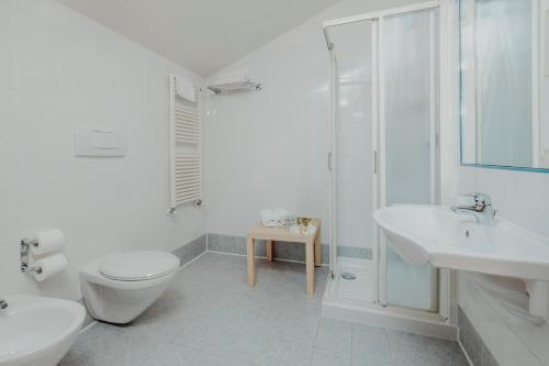 a white bathroom with a toilet and a shower at Garden Relais in Borso del Grappa