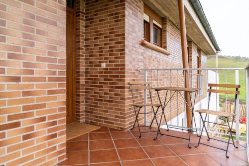 a balcony with two stools and a brick wall at Finca Seles in Ajo
