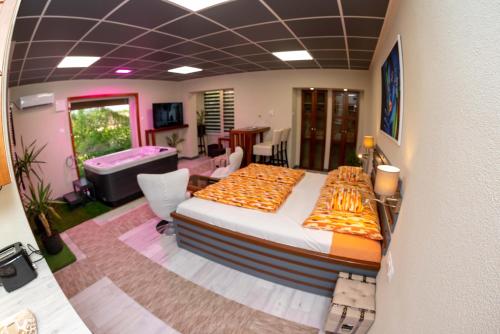a bedroom with a large bed and a living room at E14 apartman in Berekfürdő